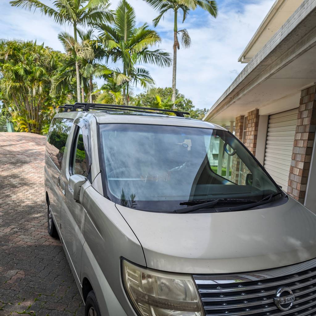 The 2004 Nissan Elgrand parked in a tropical driveway, 2024.
