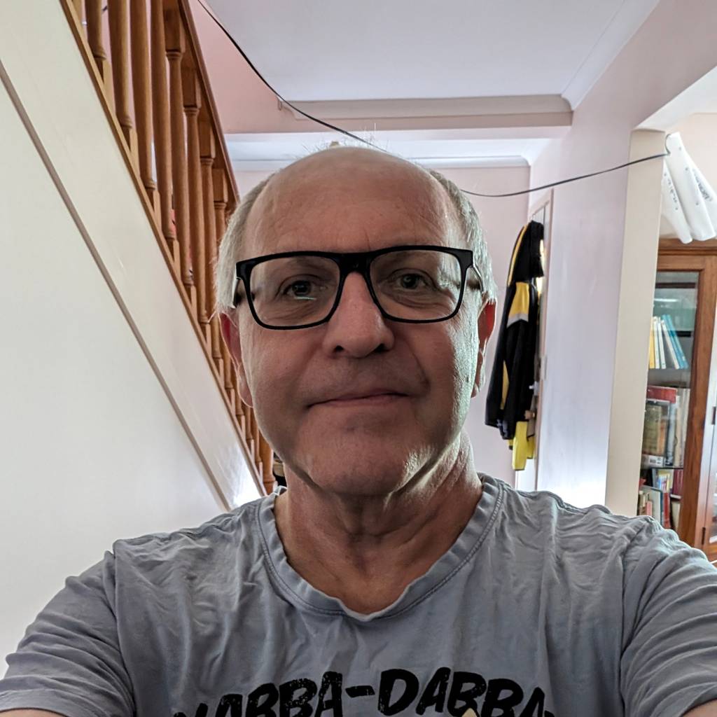 A selfie of Jacques wearing a Fred Flintstone t-shirt, 2024.