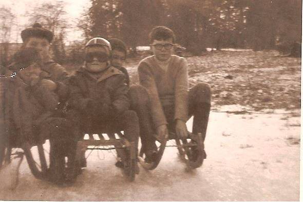 A small boy in a red helmet on a wooden sled in the snow, Soumoy, 1968.