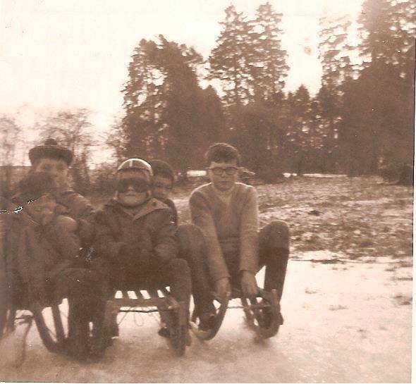 A small boy in a red helmet on a wooden sled in the snow, Soumoy, 1968.