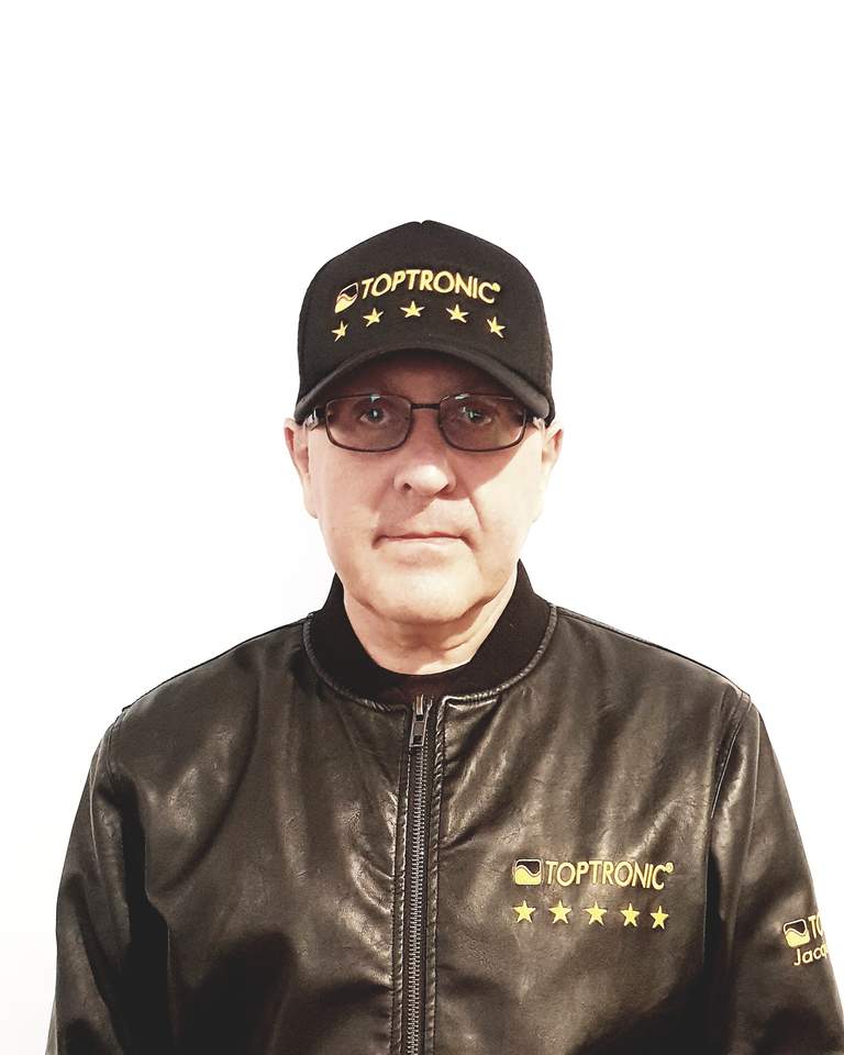 Portrait of Jacques Botte wearing the Toptronic® five-stars cap and jacket against a white background.